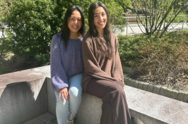 Leni and Michelle Lemos sit outside of 的 彼得T. 保罗商学院 and 经济学.